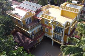 an overhead view of a yellow house with palm trees at The Royal Oasis Goa in Majorda