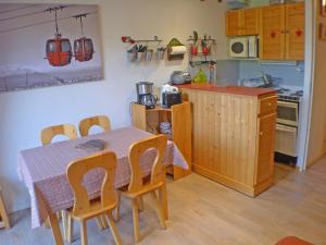 a kitchen with a table and chairs and a kitchen with a table and a kitchen at Studio Samoëns, 2 pièces, 5 personnes - FR-1-629-20 in Samoëns