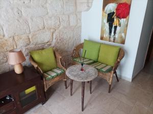 una stanza con due sedie e un tavolo e un quadro di Bombonera a Ostuni