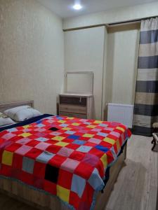 a bedroom with a colorful comforter on a bed at Recently built, new apartment Tbilisi in Tbilisi City
