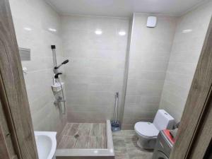 a bathroom with a shower and a toilet and a sink at Recently built, new apartment Tbilisi in Tbilisi City
