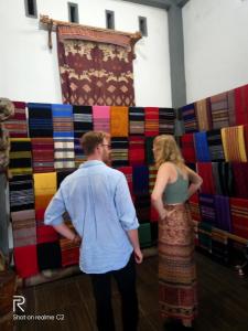 a man and woman standing in front of a wall of ties at Tereng Wilis Jungle Inn in Tetebatu