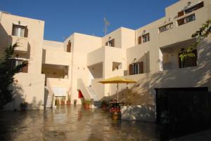 un bâtiment avec un parapluie dans une rue pluvieuse dans l'établissement Kea Holidays Houses, à Korissia