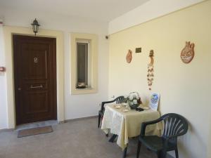 a room with a table and chairs and a door at Kea Holidays Houses in Korissia