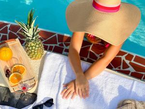 a woman in a hat sitting at a table with a tray of fruit at 2 Q Apt W Shared Pool 10 Min Clearwater Beach 4 in Clearwater