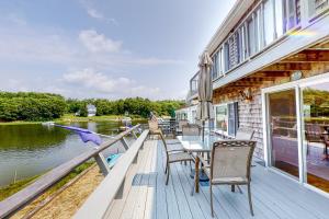 una terraza de madera con mesa y sillas en una casa en Sunset Cove Hideaway, en Wareham