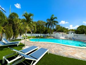 a swimming pool with lounge chairs in a yard at 2 Q Apt W Shared Pool 10 Min Clearwater Beach 4 in Clearwater