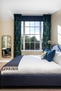 a bedroom with a large bed and a large window at The Queen's Inn in Hawkhurst