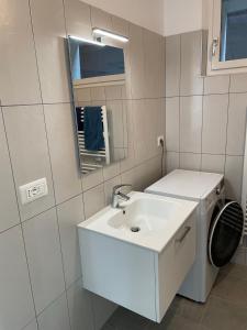 łazienka z umywalką i pralką w obiekcie Appartamento Getaway Ledro w mieście Ledro