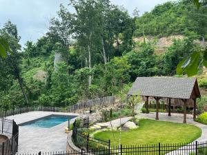 un patio trasero con piscina y cenador en Little Bear, en Gatlinburg