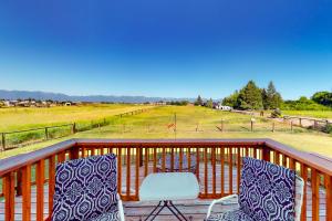 a deck with two chairs and a table and a field at Mom’s Mountain View in Somers
