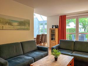 a living room with a couch and a table at Sünnslag Wohnung 131 in Boltenhagen
