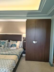ジュヴィニャックにあるSuite Deluxe vue sur Golfのベッドルーム1室(ベッド1台、木製クローゼット付)