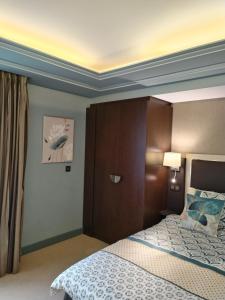a bedroom with a bed with a coffered ceiling at Suite Deluxe vue sur Golf in Juvignac