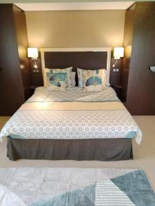 een slaapkamer met een groot bed met blauwe kussens bij Suite Deluxe vue sur Golf in Juvignac