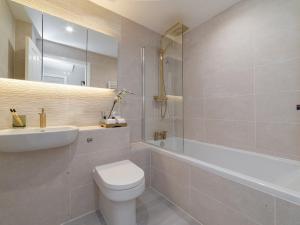 a bathroom with a toilet and a sink and a tub at Pass the Keys FLAT 2 Cozy Gem New 2 BR Near Central LondonWimbledon in London