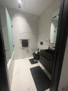 Tunis Résidence california في Le Kram: حمام مع حوض أسود ومرآة
