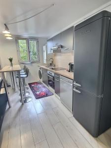 eine Küche mit einem Kühlschrank aus Edelstahl und einem Tisch in der Unterkunft Appartement Près Gare, Parking in Vigneux-sur-Seine