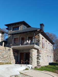 a stone house with a balcony on the front of it at CASA RURAL PAJARICA en Sanabria in San Ciprián