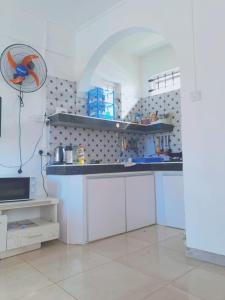 a kitchen with white cabinets and a bird on the wall at 1st floor apartment out of three with pool near sandy beach nearby to rent in Pointe aux Biches
