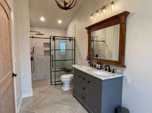 a bathroom with a sink and a toilet and a mirror at Beautiful Craftsman Home with Riverfront Views! in Lander