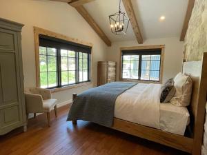 a bedroom with a bed and a chair and windows at Beautiful Craftsman Home with Riverfront Views! in Lander
