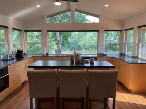 a kitchen with a large island with chairs in it at Beautiful Craftsman Home with Riverfront Views! in Lander
