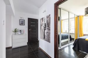 a bedroom with a mirror and a bed and a window at SuperApart Puławska 119 in Warsaw