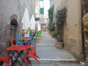 Une allée avec des tables, des chaises et des parasols dans l'établissement La Fontanella, à Pitigliano