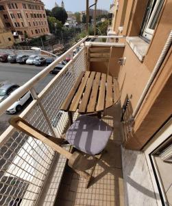 un banc en bois assis sur le balcon d'un bâtiment dans l'établissement La Casetta Azzurra, à Rome