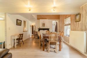 a dining room and living room with a table and chairs at De Groene Hoeve in Brakel