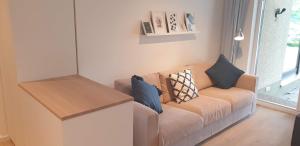 ein Wohnzimmer mit einem Sofa mit Kissen darauf in der Unterkunft Sommertraum mit eigenem Steg und Liegewiese in Pöcking