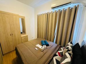 a bedroom with a bed and a window with curtains at Taguig 1 Bedroom with balcony Grace Residences Near Bgc in Manila