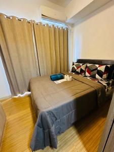 a bedroom with a bed and a window at Taguig 1 Bedroom with balcony Grace Residences Near Bgc in Manila