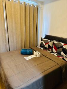 a bed with two towels and two cups on it at Taguig 1 Bedroom with balcony Grace Residences Near Bgc in Manila