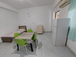 een kleine kamer met een tafel en een koelkast bij Jungle House in Borsh