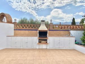 una cocina al aire libre con chimenea en el patio trasero en Casita de La Alquería, en Málaga