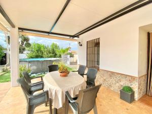 Un comedor con mesa y sillas en un patio. en Casita de La Alquería, en Málaga