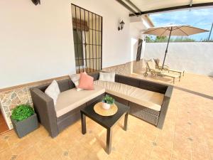 sala de estar con sofá y sombrilla en Casita de La Alquería, en Málaga