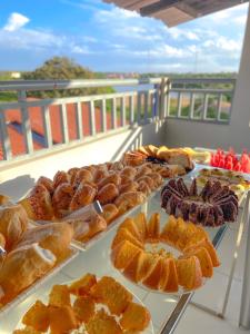 ein Buffet mit Brot und Gebäck auf dem Balkon in der Unterkunft Canto da Duna Hotel in Barreirinhas