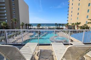 vista su una piscina con sedie e sull'oceano di Crystal Tower 208 a Gulf Shores