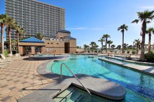 una gran piscina con un edificio y palmeras en Crystal Tower 208 en Gulf Shores