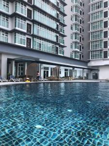 a swimming pool in front of a building at Backpackers Cozy Apartment KL Sentral in Kuala Lumpur