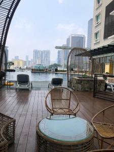 a balcony with chairs and a view of the water at Backpackers Cozy Apartment KL Sentral in Kuala Lumpur