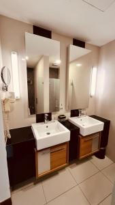 a bathroom with two sinks and a large mirror at Backpackers Cozy Apartment KL Sentral in Kuala Lumpur