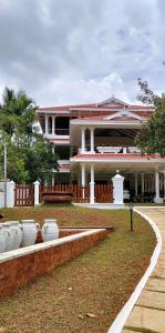 a large building with a garden in front of it at The Cana's Coorg in Ammatti