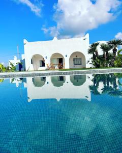 a villa with a swimming pool in front of a house at Villa viewpoint infinity pool jardin aucun vis-à-vis in Ḩammām al Ghazzāz