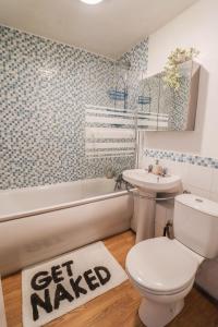 a bathroom with a toilet and a sink and a tub at Spacious 1 bed flat-FREE Parking in New Bedfont
