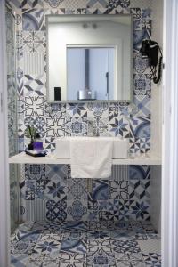 a bathroom with blue and white tiles and a mirror at Sweet San Francisco in Alicante