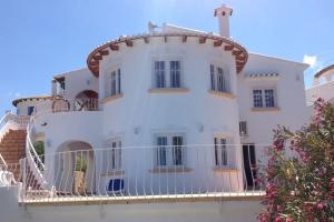 a large white house with a balcony at Casa La Vida, stijlvolle Spaanse villa met uniek uitzicht! in Benitachell